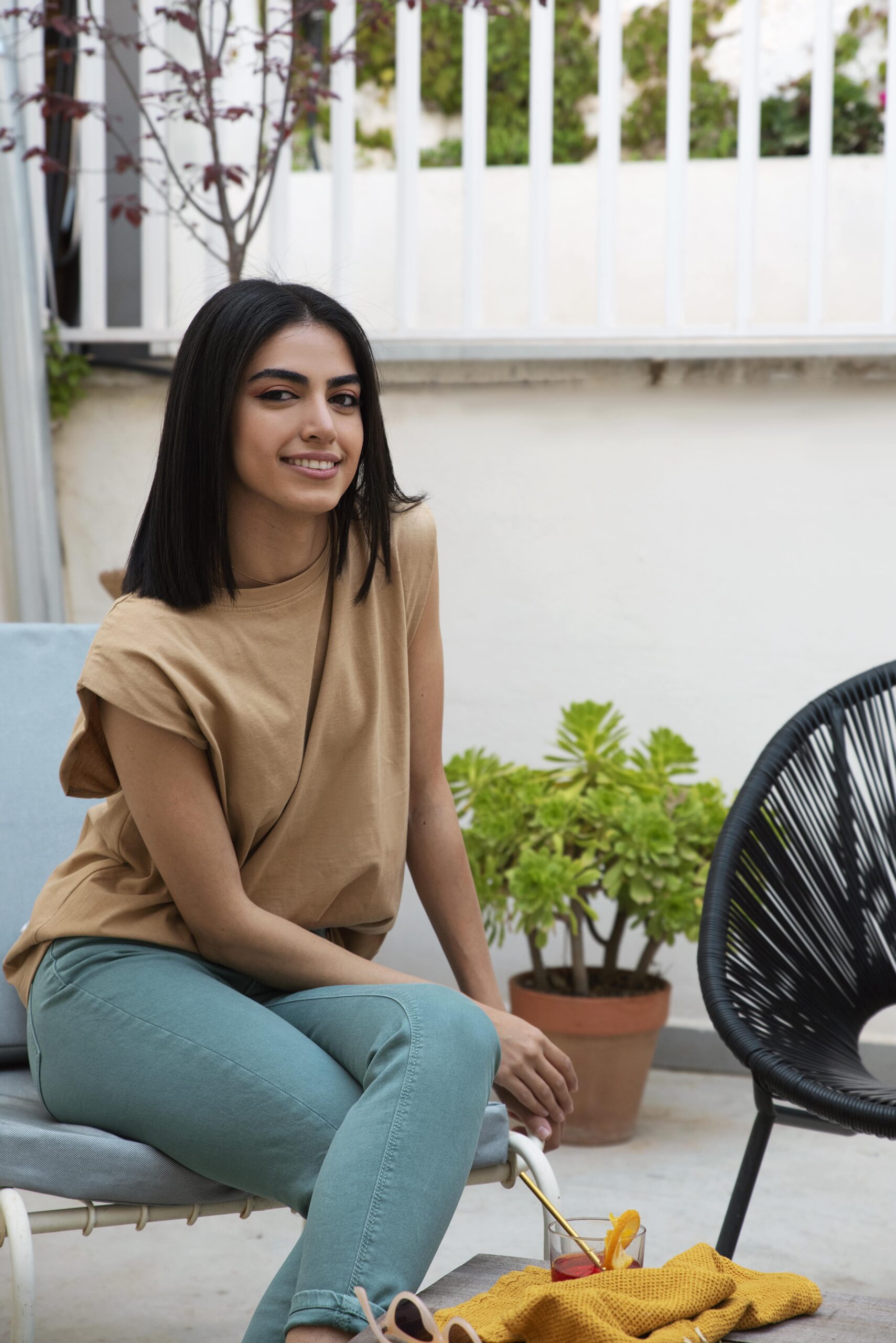 full-shot-smiley-woman-sitting-chair-min